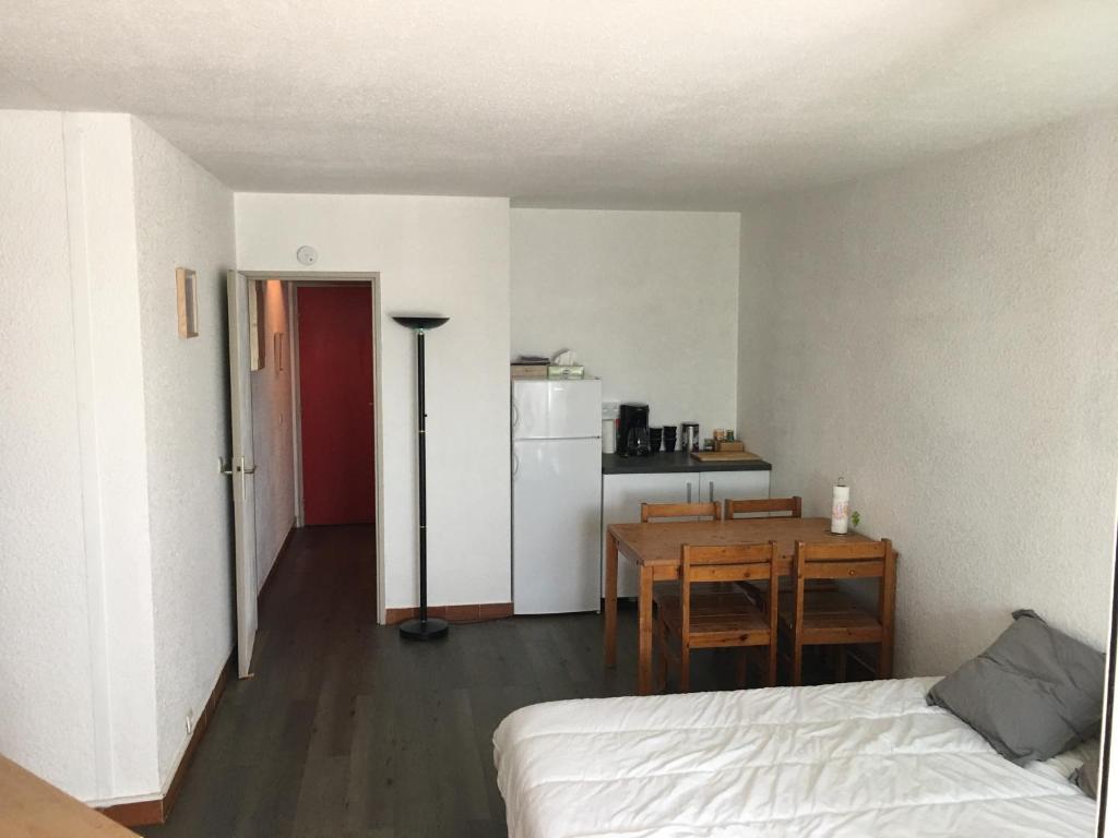a room with a bed and a table and a kitchen at Studio 233, Port Camargue, Parking, WiFi, Piscine, 2 personnes in Le Grau-du-Roi
