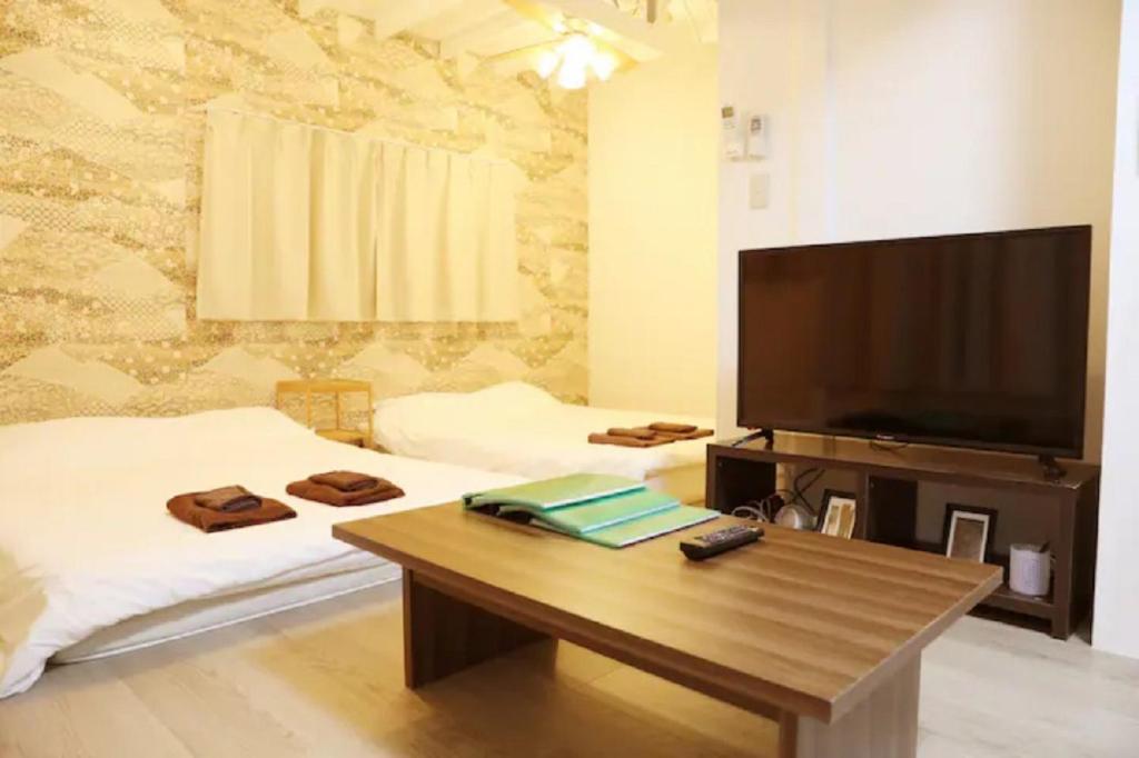 een woonkamer met een grote televisie en een salontafel bij Takano Private Rental House - Vacation STAY 32311v in Tokyo