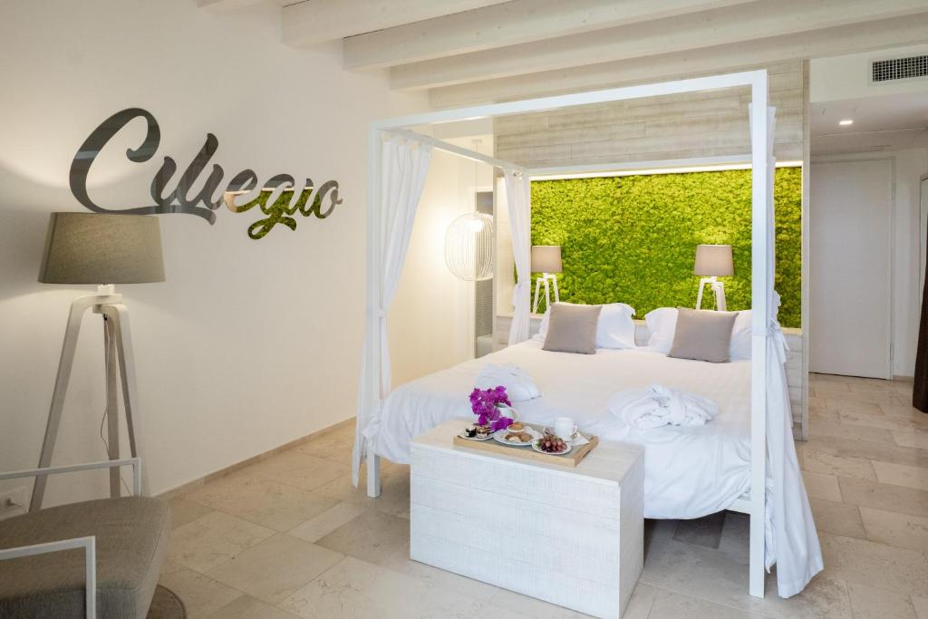a bedroom with a white bed with a sign on the wall at San Lorenzo Boutique Hotel & SPA in Polignano a Mare