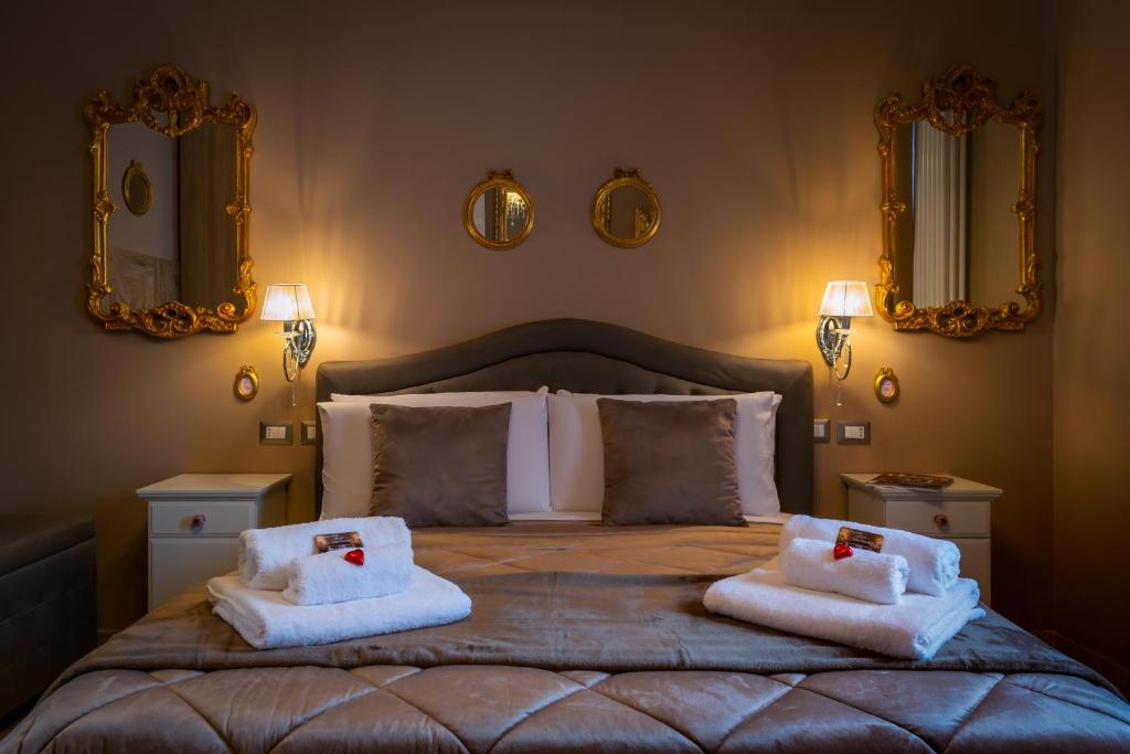 - une chambre avec un grand lit et des serviettes dans l'établissement Dolce Casa Villa Laura, à Bologne
