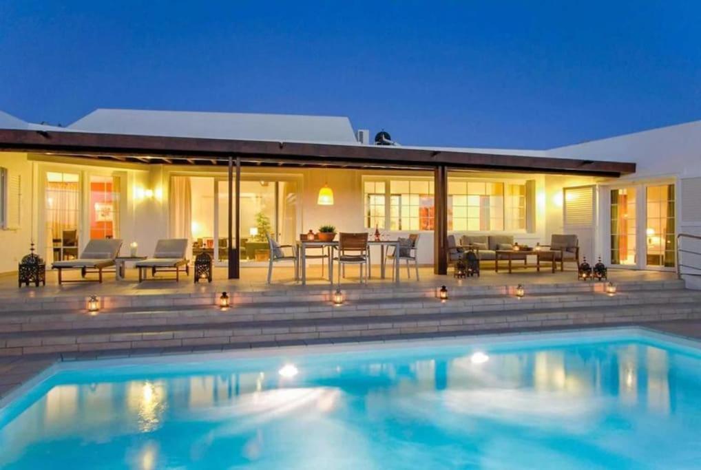 a swimming pool in front of a house at Villa Perla in Puerto del Carmen