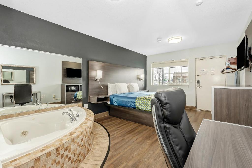een hotelkamer met een bad en een bed bij Grove City Travel Inn in Grove City