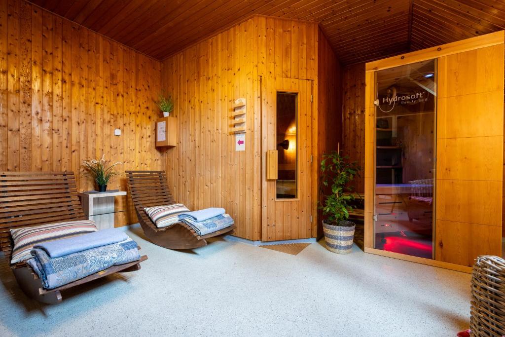 una habitación con paredes y sillas de madera y un edificio en Weinhotel Restaurant Klostermühle en Ockfen