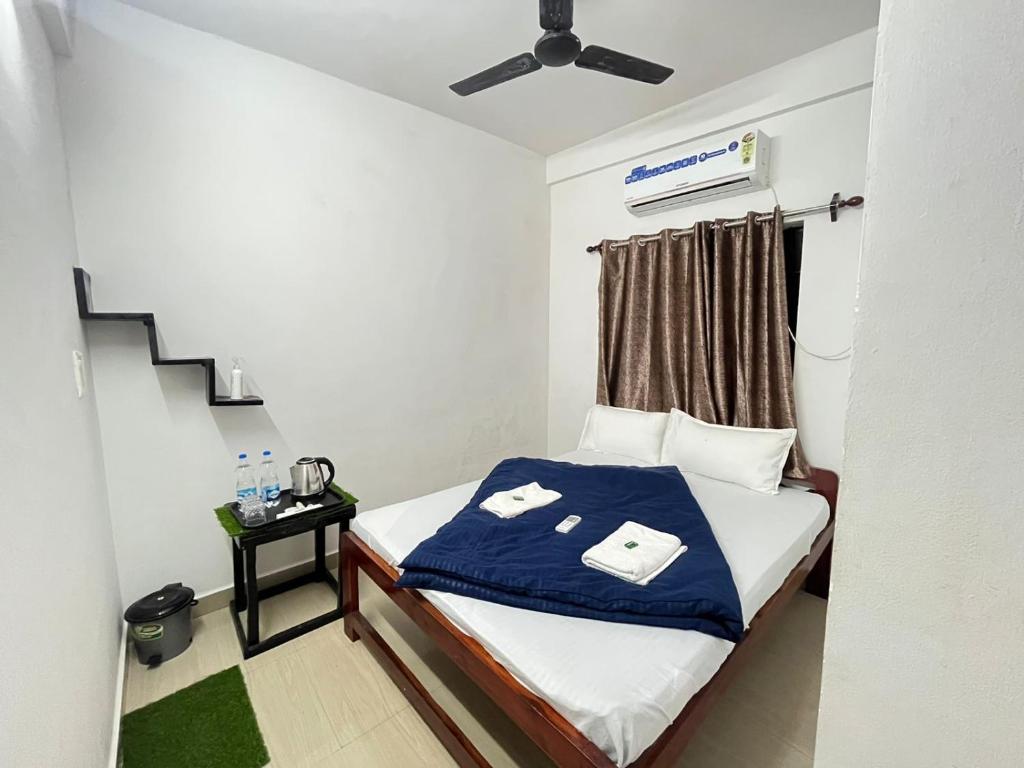 a small bedroom with a bed with a blue blanket at HAKUNA MATATA - Best budget stay at Arambol Beach, Goa in Arambol