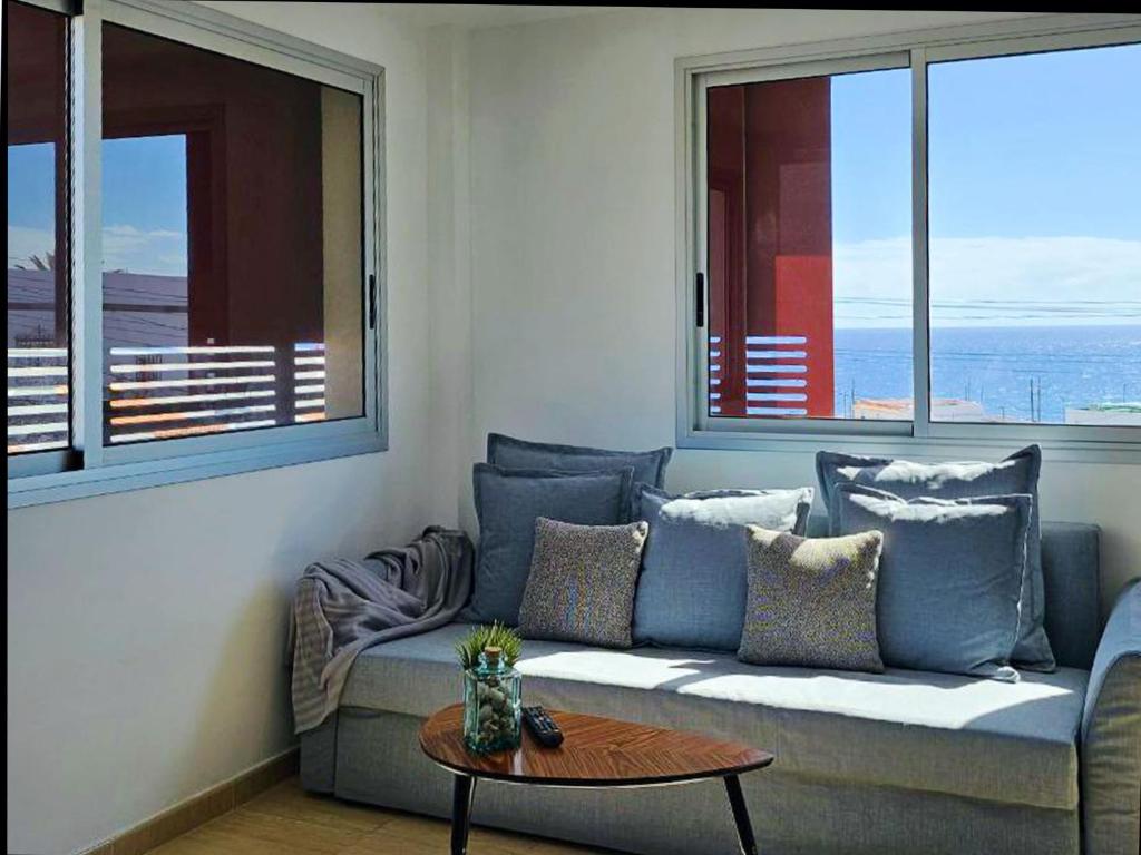 a living room with a couch and two windows at Live Poris La Morra in Poris de Abona