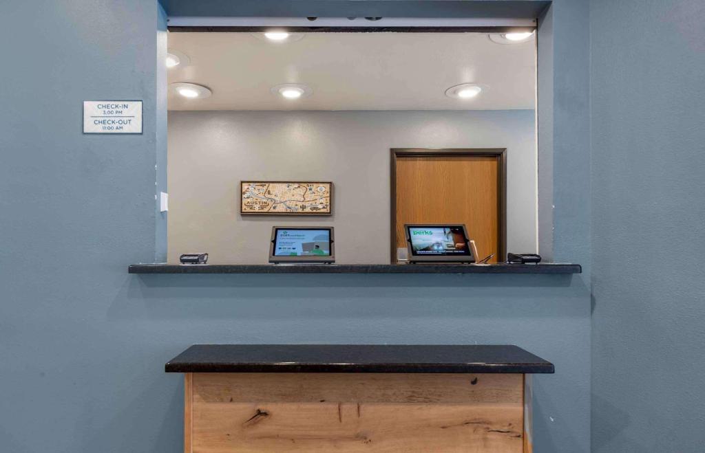 a counter with two laptops on a blue wall at WoodSpring Suites Austin Northwest in Austin
