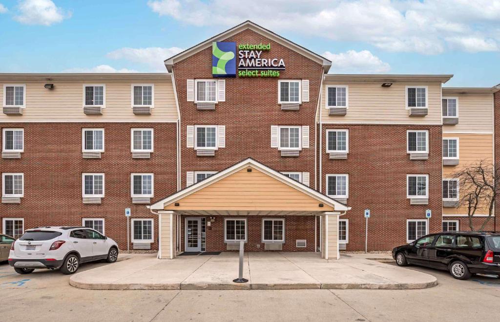 un grande edificio in mattoni rossi con un cartello sopra di Extended Stay America Select Suites - Indianapolis - Greenwood a Greenwood