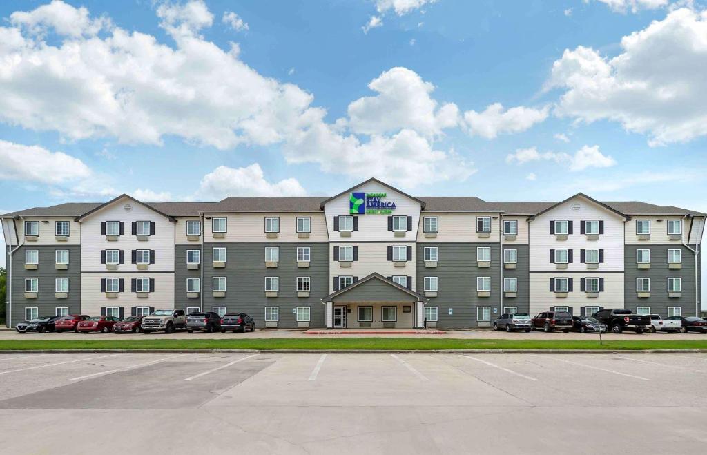 a large building with cars parked in a parking lot at Extended Stay America Select Suites - Beaumont in Beaumont