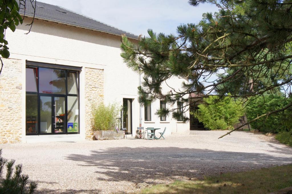 a white house with a picnic table in front of it at Ferme Sainte Marie in Rémilly