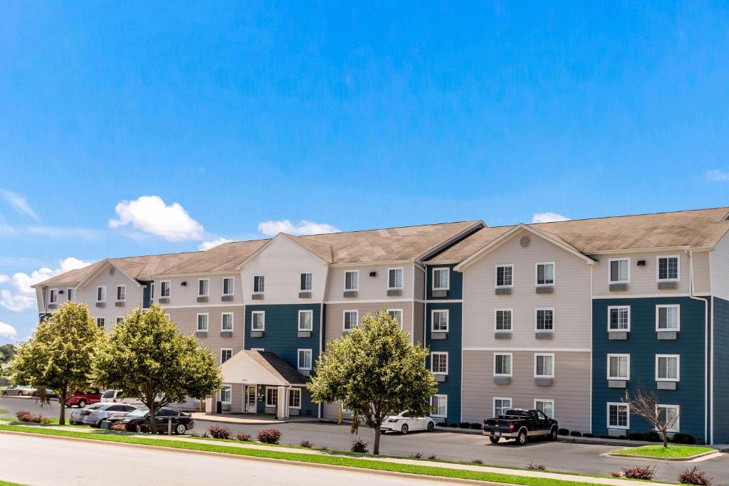 eine Darstellung eines Apartmenthauses mit draußen geparkt in der Unterkunft Extended Stay America Select Suites - Fayetteville in Fayetteville