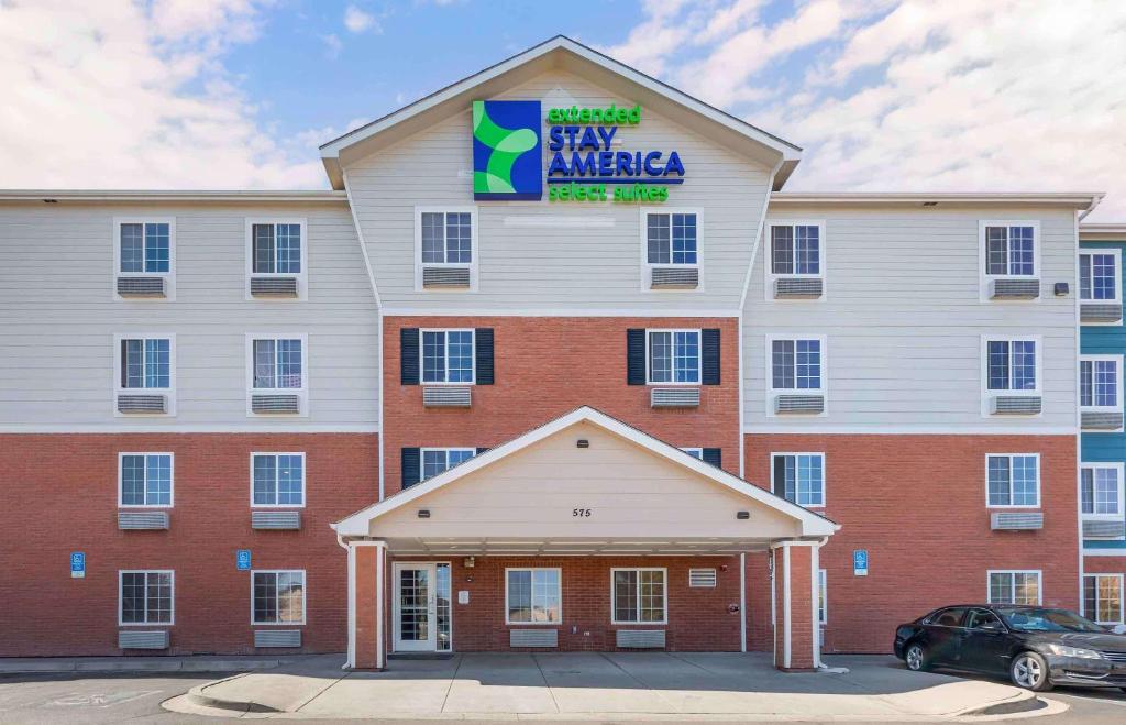 a large red and white building with a sign on it at Extended Stay America Select Suites - Denver - Aurora in Aurora