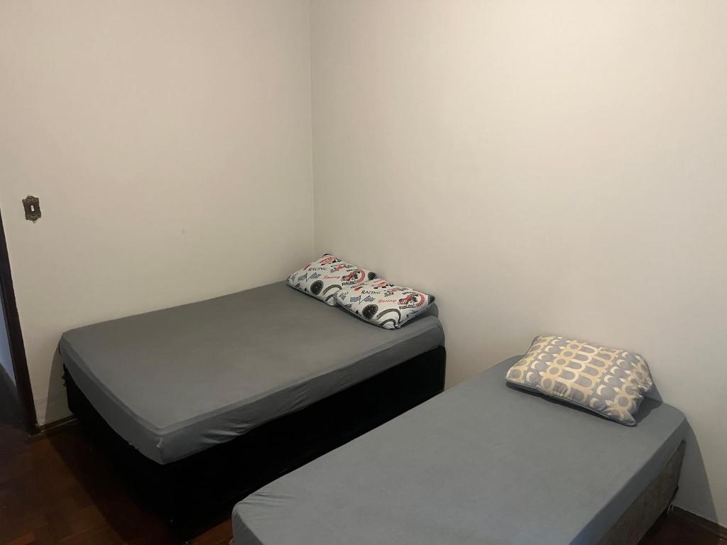 two twin beds in a small room with at Pousada âncora in Uberlândia