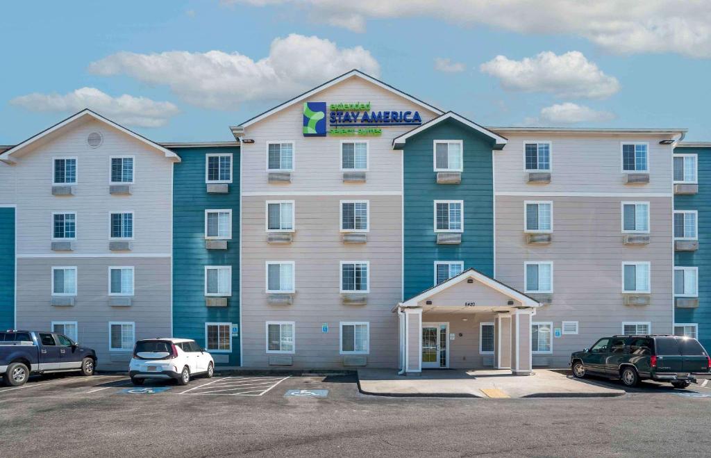 un gran edificio de apartamentos con coches aparcados en un aparcamiento en Extended Stay America Select Suites - Gulfport, en Gulfport