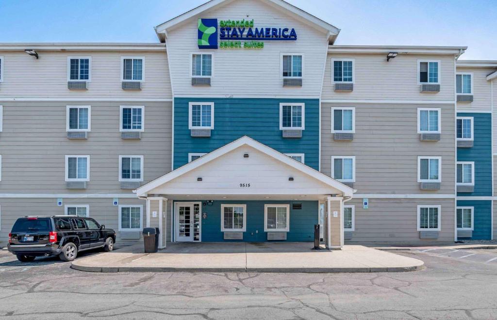 a large building with a car parked in front of it at Extended Stay America Select Suites - Indianapolis - Lawrence in Fishers