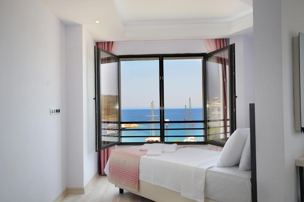 a bedroom with a bed and a large window at Datca Sapphire Hotel in Datca