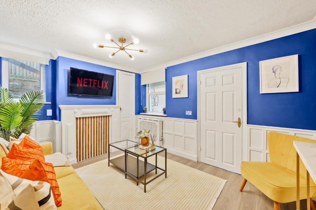 een woonkamer met blauwe muren en een deur bij Bright 1 Bed with free NETFLIX in Chatham