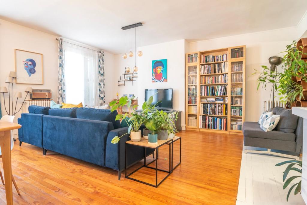 a living room with a blue couch and bookshelves at Escapade Culturelle Havraise in Le Havre