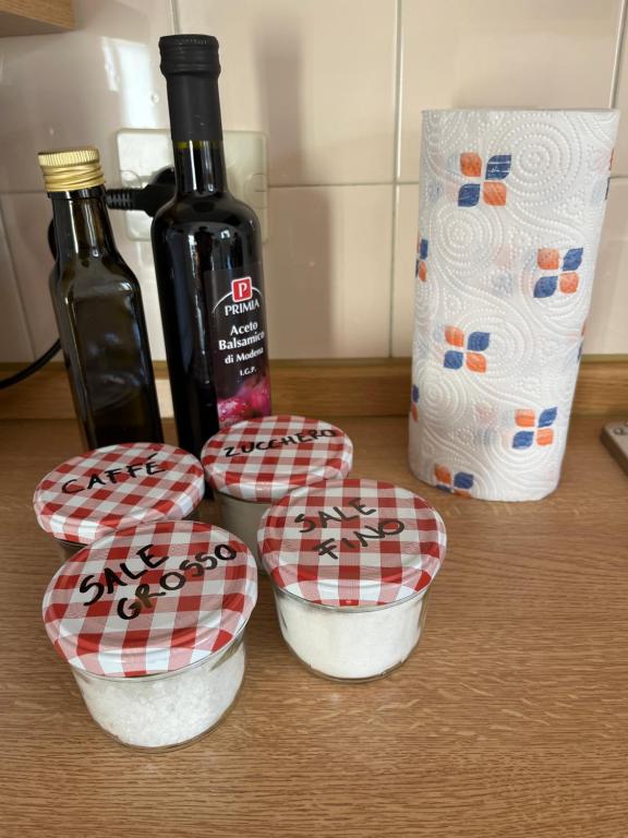 a group of four bowls on a counter with a bottle of wine at DOLOMITI HOUSE 4 in Fiera di Primiero