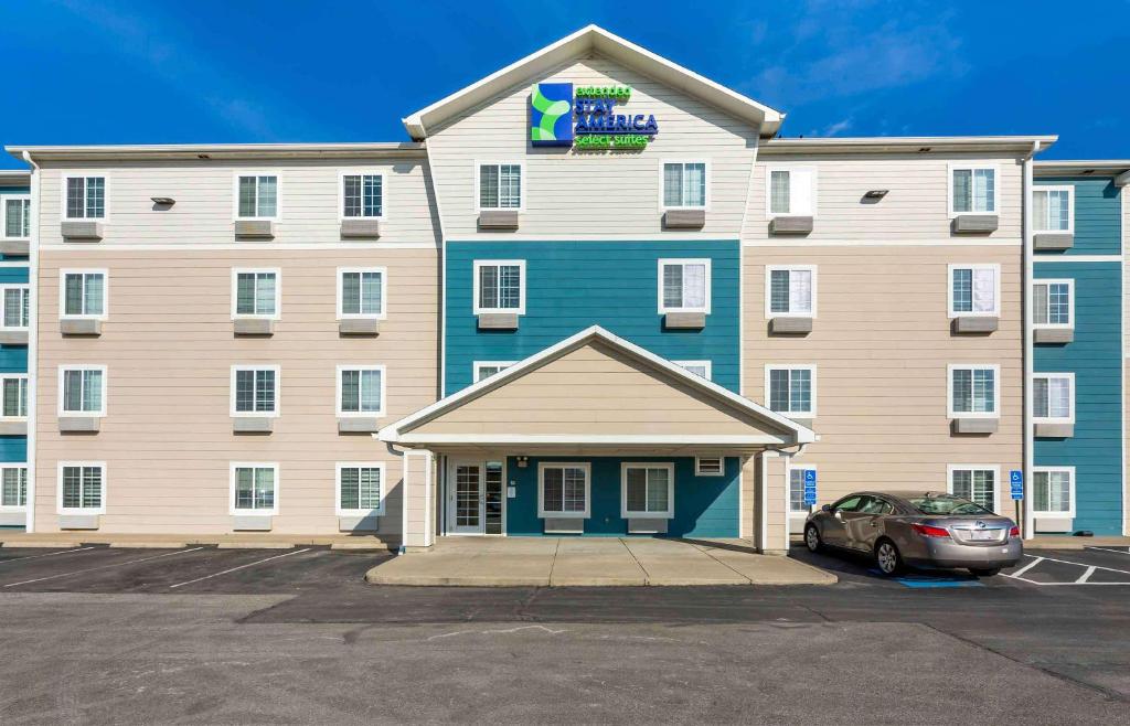 a large building with a car parked in front of it at Extended Stay America Select Suites - Cleveland - Avon in Avon