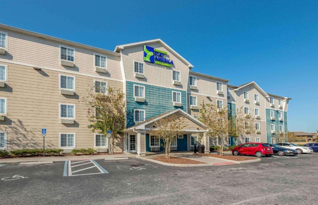 un hotel con un coche aparcado en un aparcamiento en Extended Stay America Select Suites - Orlando - East, en Orlando