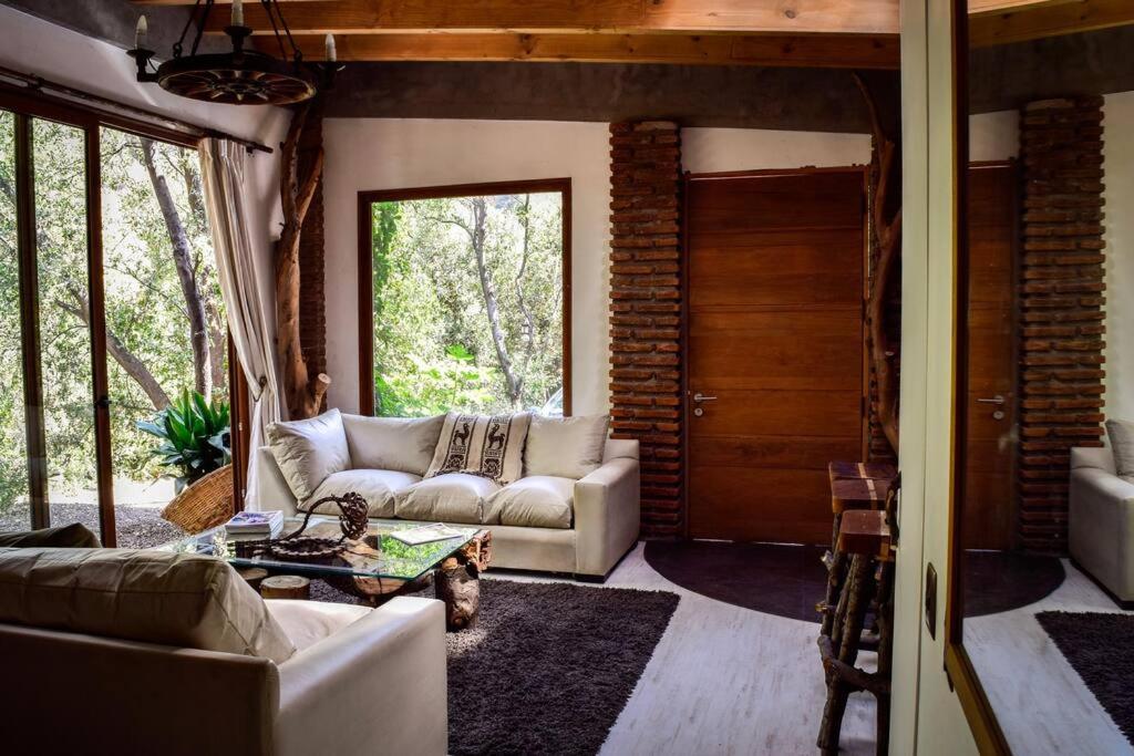sala de estar con sofá y mesa en Iluminada casa de piedra entre bosque y río, en Lo Barnechea