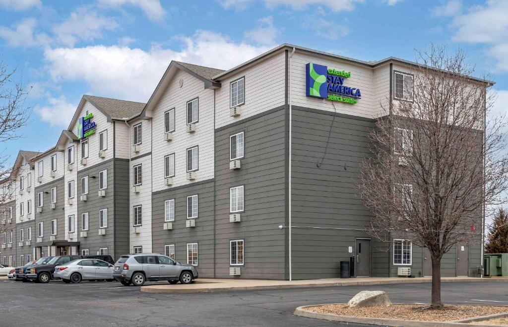 a large building with cars parked in a parking lot at Extended Stay America Select Suites - Wichita - North in Wichita