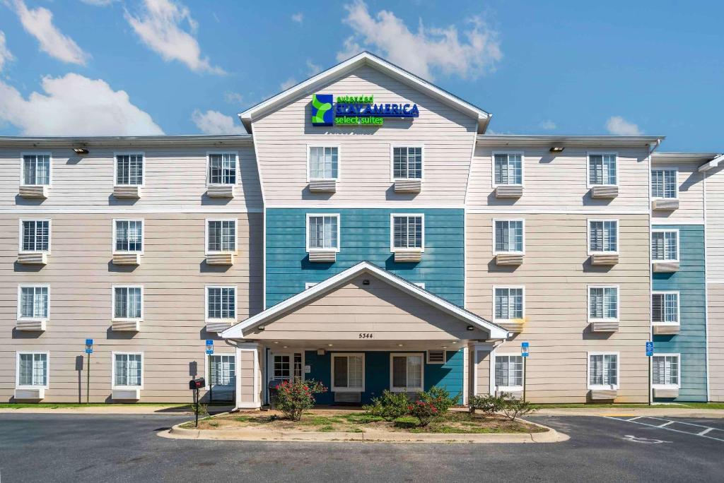 un gran edificio blanco y azul con un cartel. en Extended Stay America Select Suites - Tallahassee - Northwest en Tallahassee