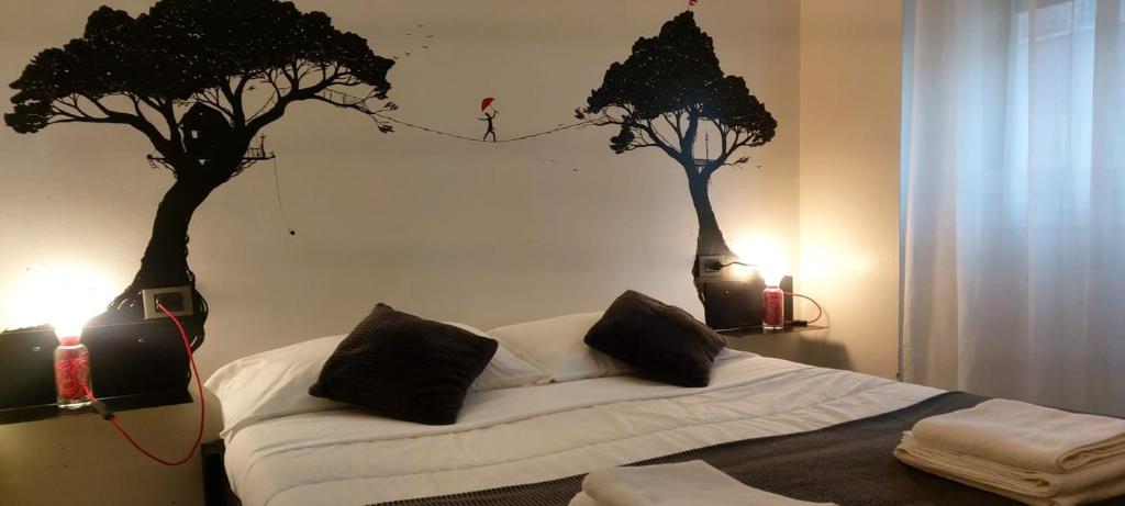 a bedroom with two trees painted on the wall at Street Art Inn Florence in Florence