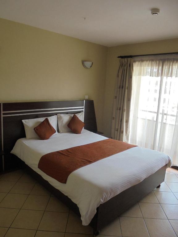 Postel nebo postele na pokoji v ubytování Nairobi Transit Hotel