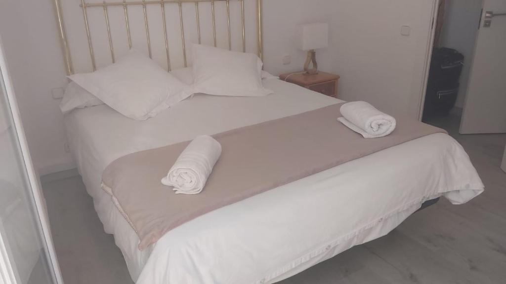 uma cama branca com lençóis e almofadas brancos em Chopin Magic Fountain em Barcelona