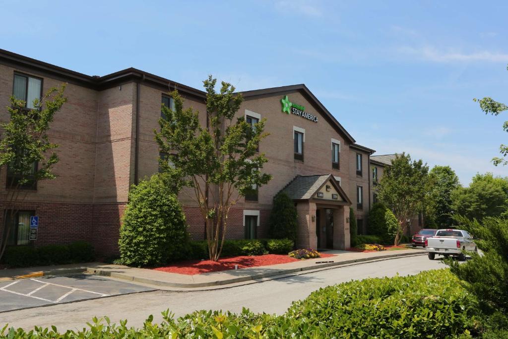 a hotel building with a car parked in front of it at Extended Stay America Select Suites - Atlanta - Alpharetta - Northpoint - East in Alpharetta