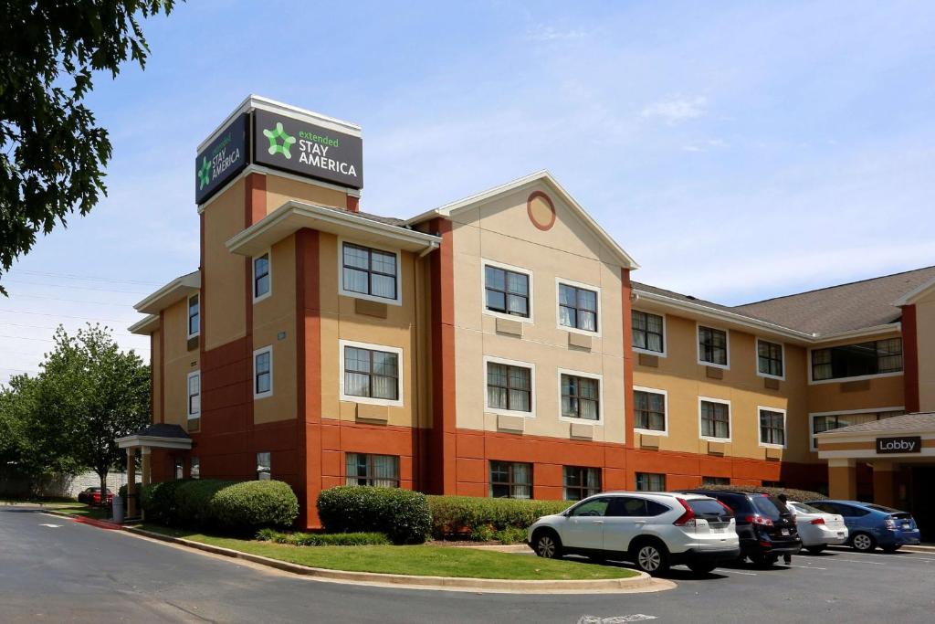 um hotel com carros estacionados num parque de estacionamento em Extended Stay America Suites - Atlanta - Kennesaw Town Center em Kennesaw