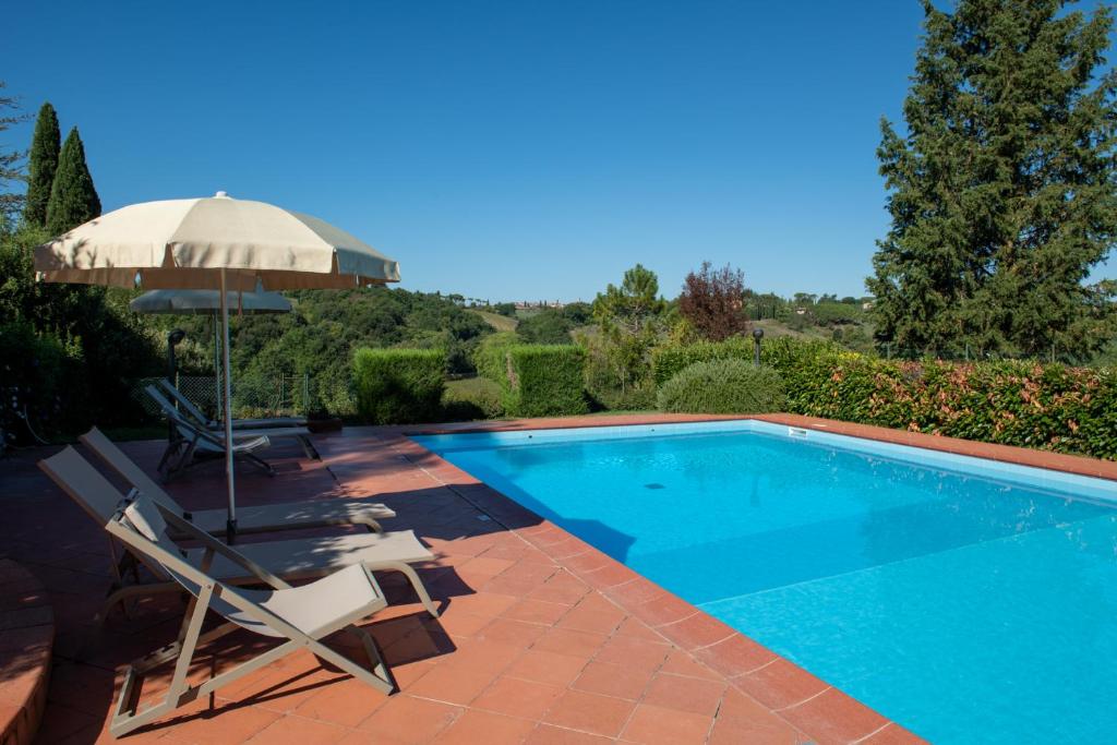 uma piscina com um guarda-sol e duas cadeiras e um guarda-sol em Agriturismo Il Colle em Siena