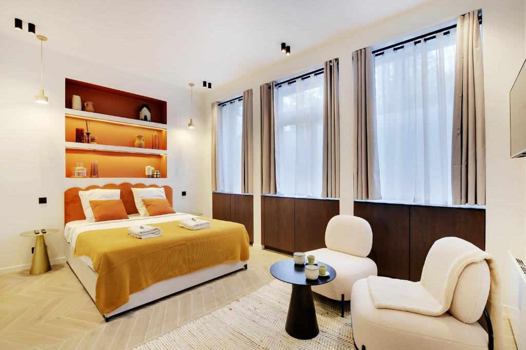 - une chambre avec un lit king-size et une chaise dans l'établissement Saint Ambroise COSY SUITE 2P 1BDR, à Paris