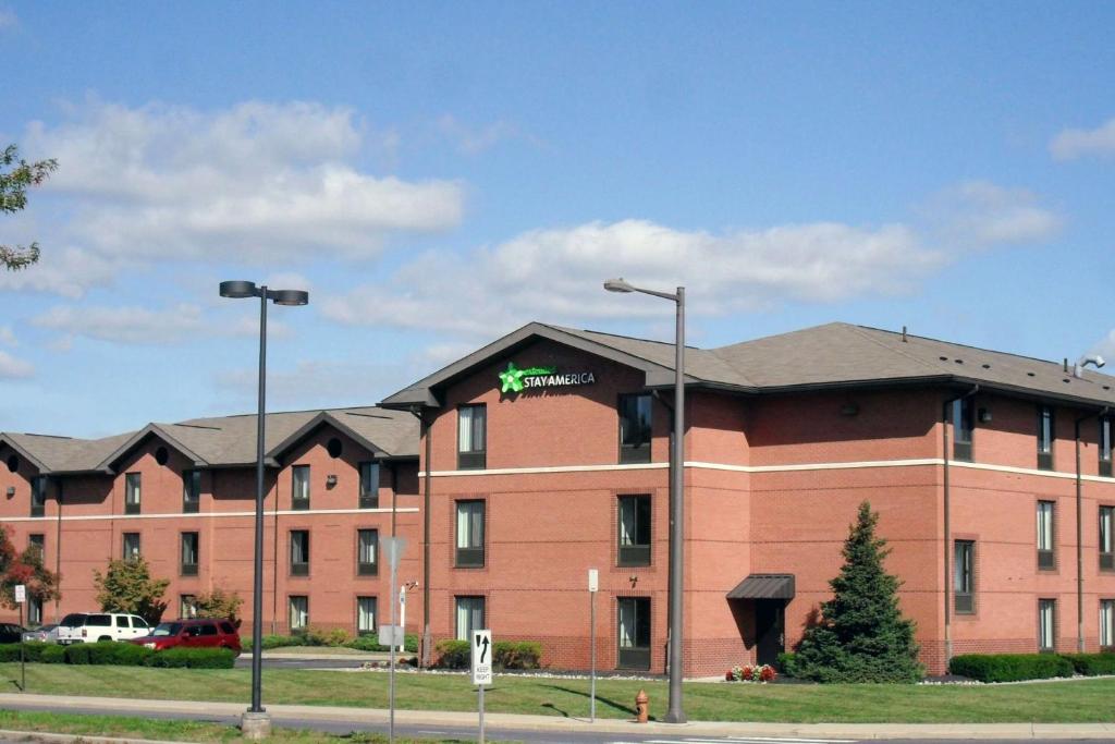 um grande edifício de tijolos vermelhos com um sinal nele em Extended Stay America Suites - Philadelphia - Airport - Bartram Ave em Filadélfia