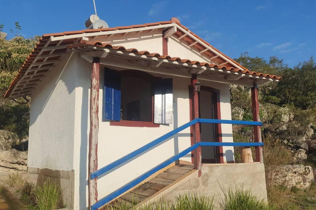 a small house with a blue staircase in front at Chalé Serra do Ouro in Diamantina
