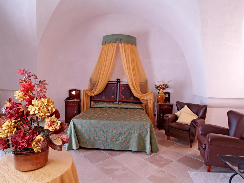 a bedroom with a bed with a canopy at Hotel Masseria Tutosa in Ostuni