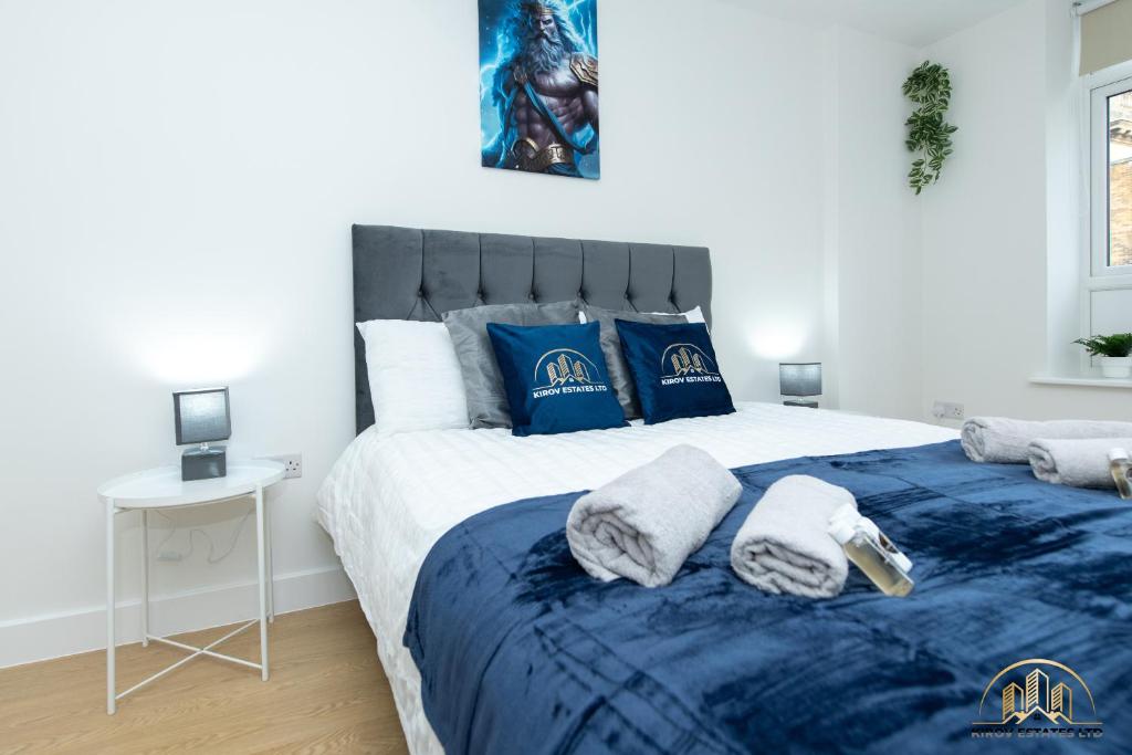 um quarto com uma cama azul e branca com toalhas em Zeus Apartment - The Thunder of Town em Southampton