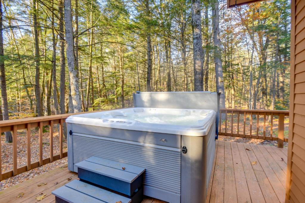 a hot tub on a deck with trees in the background at North Conway Vacation Rental Near Saco River! in North Conway