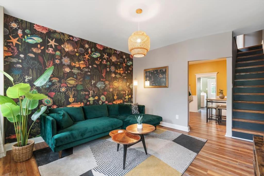 a living room with a green couch and a wall mural at Trendy Fishtown Mid-Century Modern Inspired Home in Philadelphia
