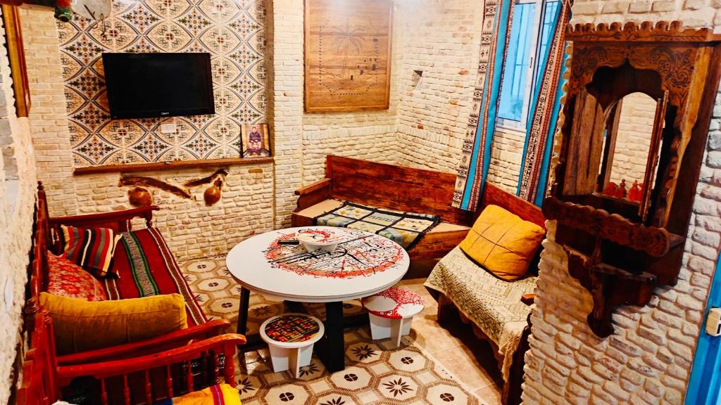 Kleines Zimmer mit einem Tisch und einem TV. in der Unterkunft Appartement Berbère in Tozeur