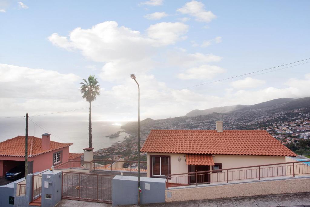 uma casa com uma palmeira e vista em Slice of Paradise- Palheiro de Golf em Funchal