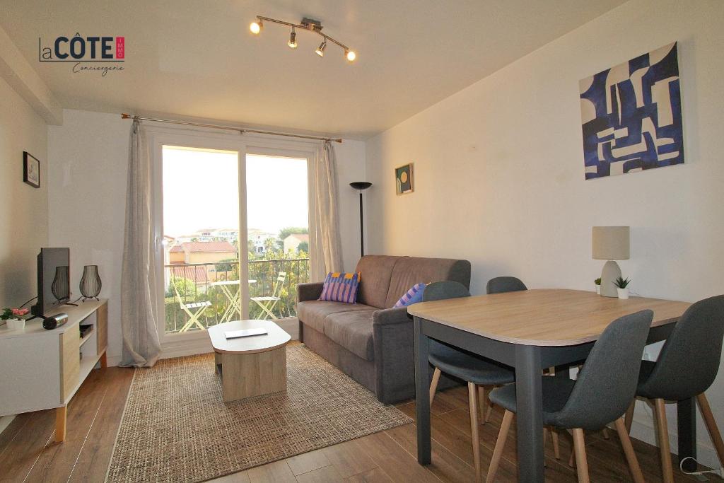 un salon avec un canapé et une table dans l'établissement L'escandiado - 4 couchages, à Sausset-les-Pins