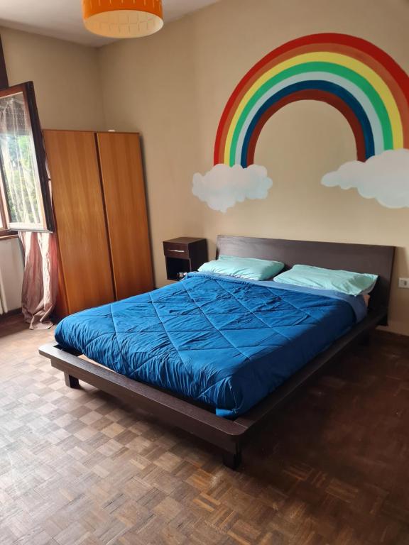 a bed with a rainbow painted on the wall at VILLA GIOVANNA in Bergamo