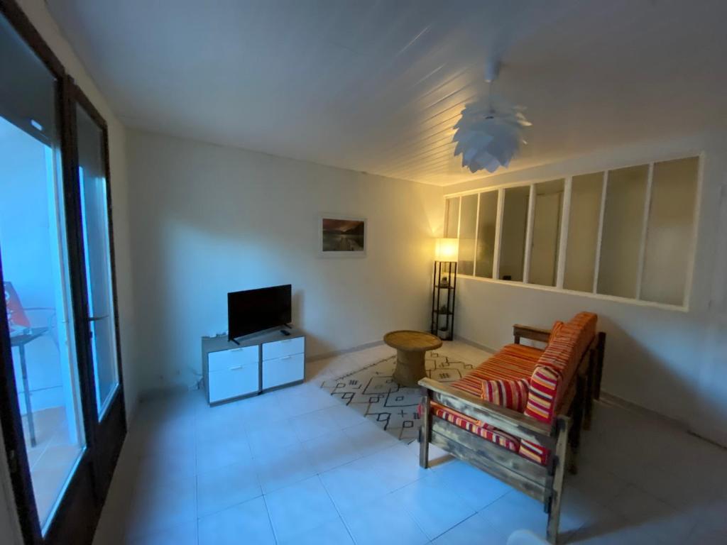 ein Wohnzimmer mit einem Sofa und einem TV in der Unterkunft T2 rdc Muret in Muret