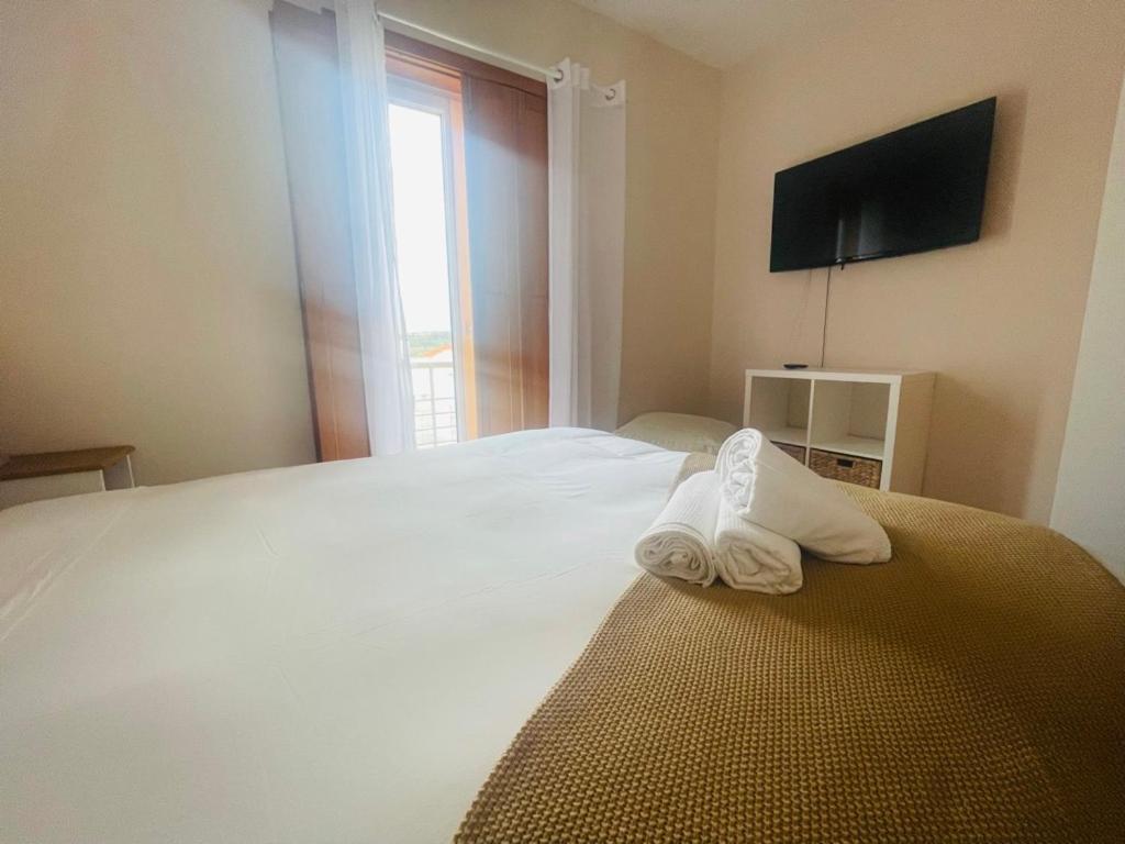 um quarto com uma cama com duas toalhas em Casa Sonia Great location Quiet area Easy access em Óbidos
