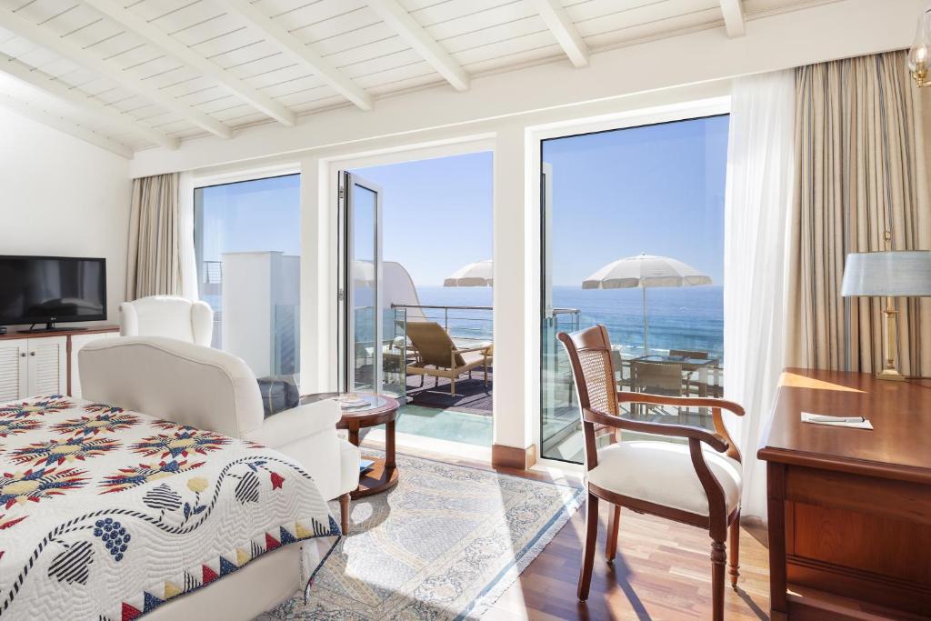 Schlafzimmer mit einem Bett und einem Schreibtisch mit Meerblick in der Unterkunft Residence Estrela do Mar in Salema