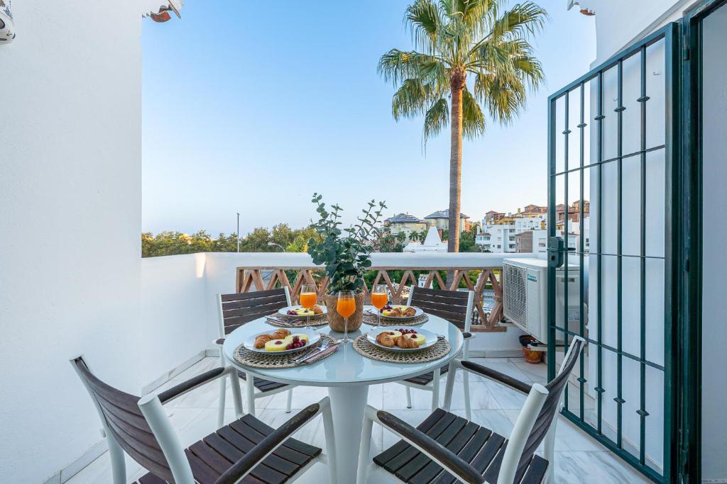einen Balkon mit einem Tisch mit Essen drauf in der Unterkunft 797 HOLIDAY RENTALS - Apartamento en Pueblo del Parque in Arroyo de la Miel