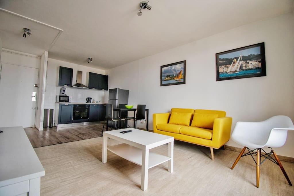 un salon avec un canapé jaune et une table dans l'établissement Joli T2 lumineux avec balcon et wifi - proche CV, à Aix-en-Provence
