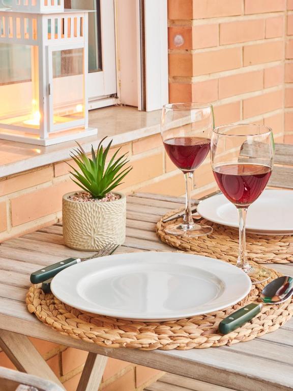 two glasses of wine and a plate on a table at EL RINCÓN VERDE in Puerto de Sagunto